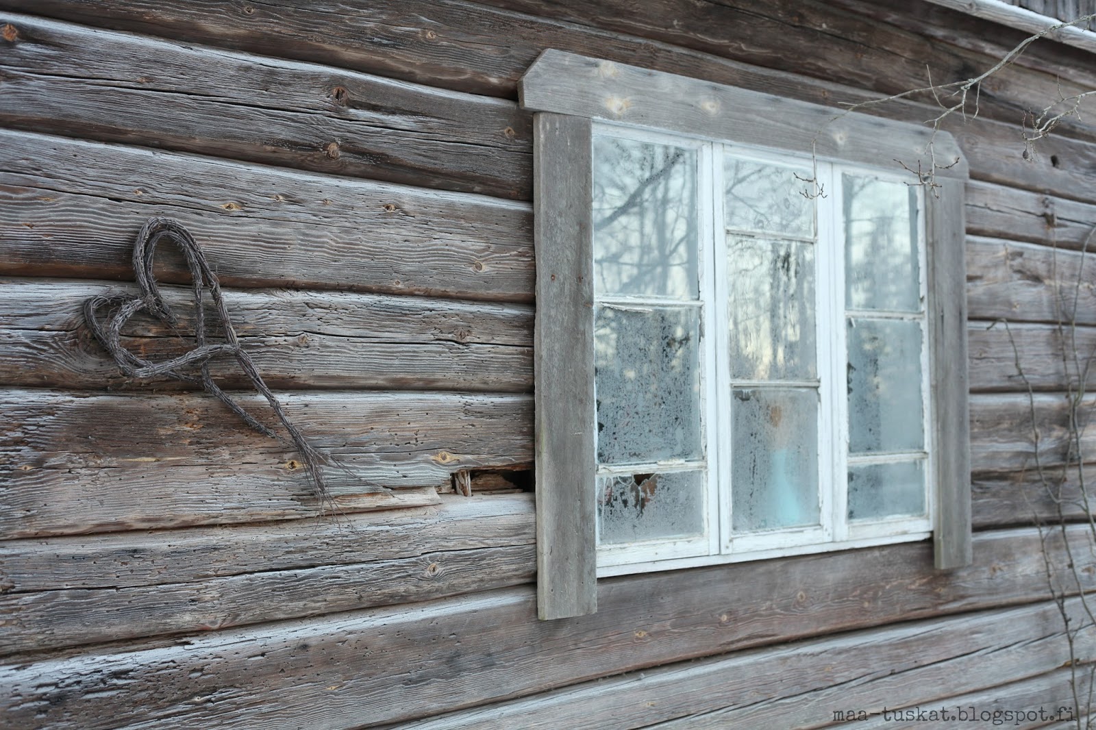 vanha rikkinäinen ikkuna ja risuista tehty sydän